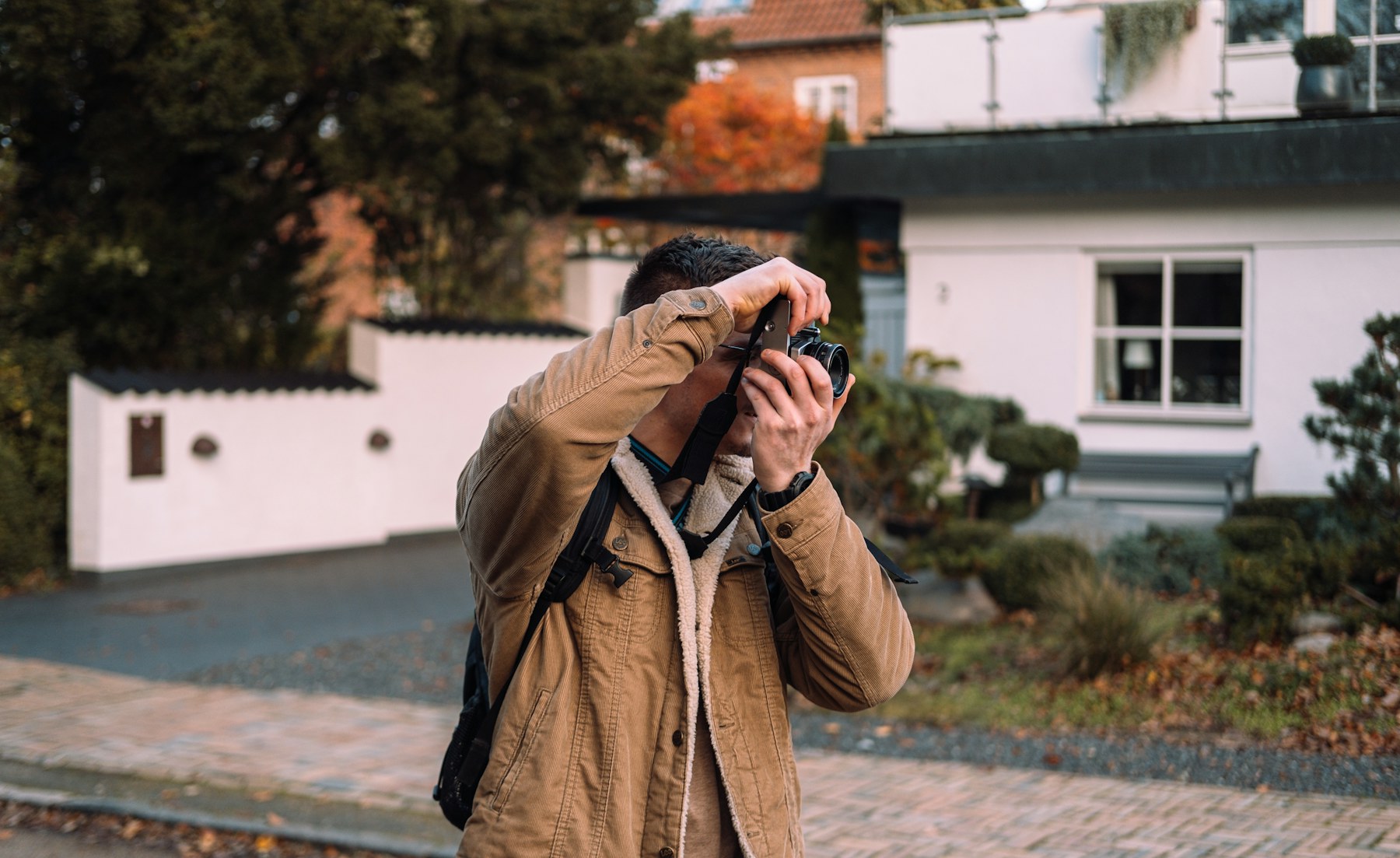 Professional male photographer holding a DSLR camera outdoors